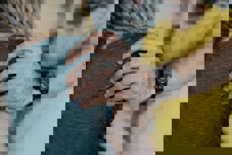 Close-up of a man’s hand gripping a woman’s shoulder, suggesting control or unwanted contact.