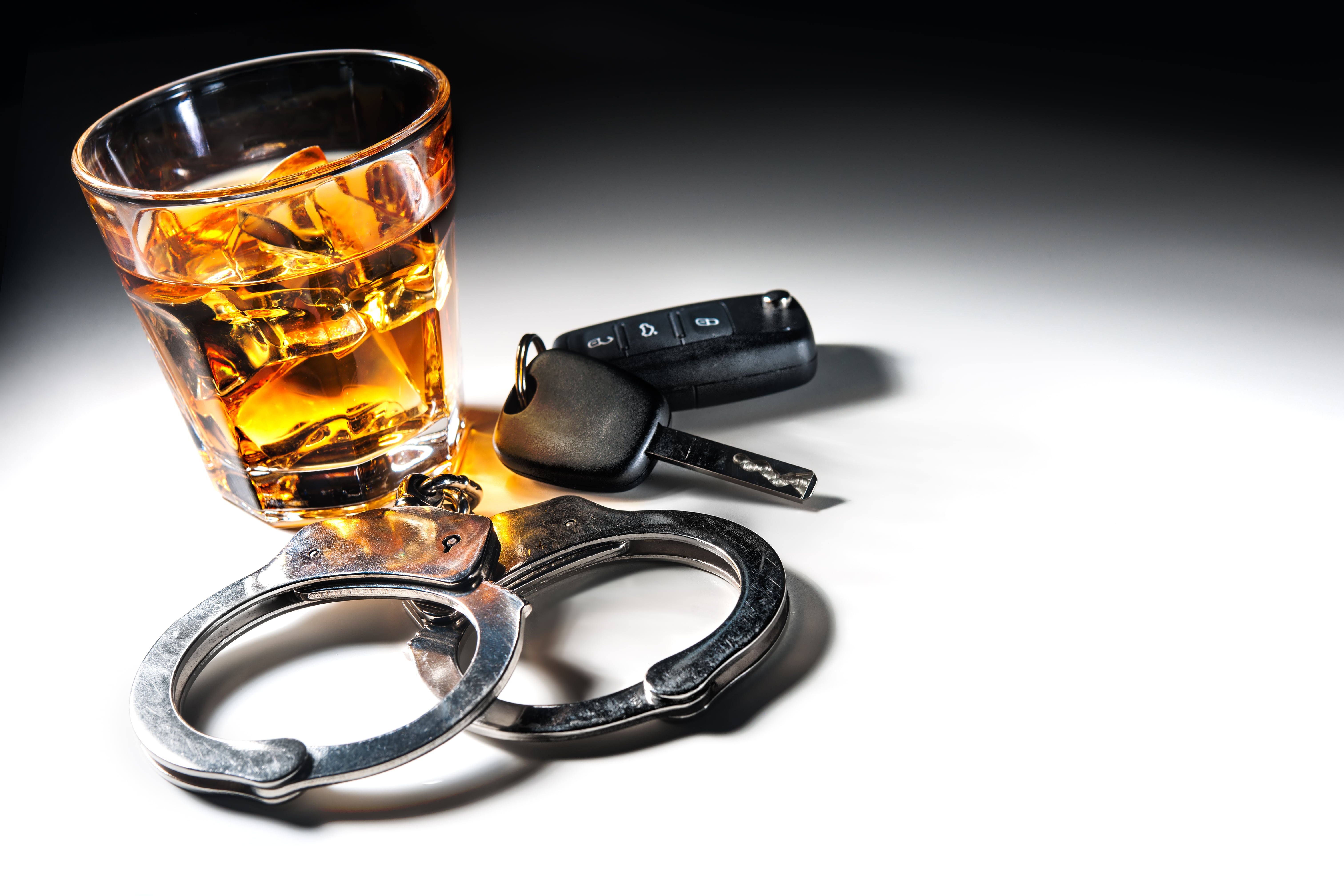 Glass of alcohol with car keys and handcuffs - if you've been charged with a DWI call our Minneapolis DWI lawyer